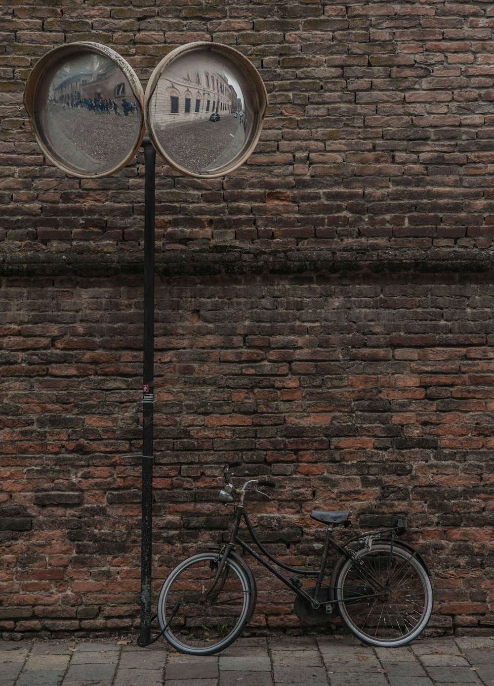 a bicycle parked next to a brick wall