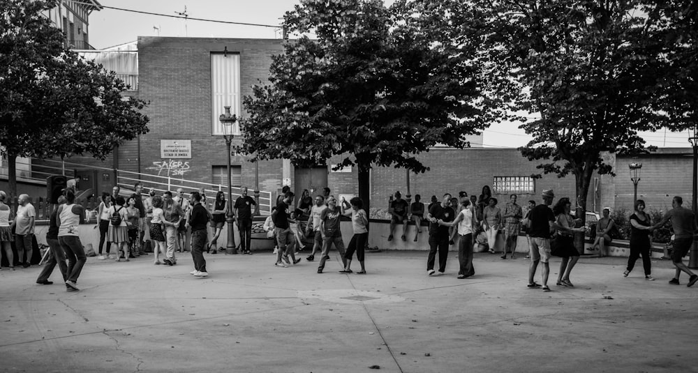 a group of people standing around in a parking lot