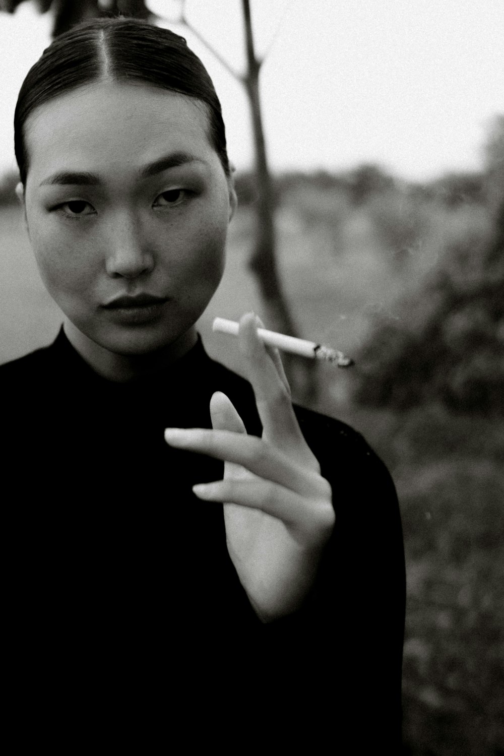 a woman smoking a cigarette in a black shirt