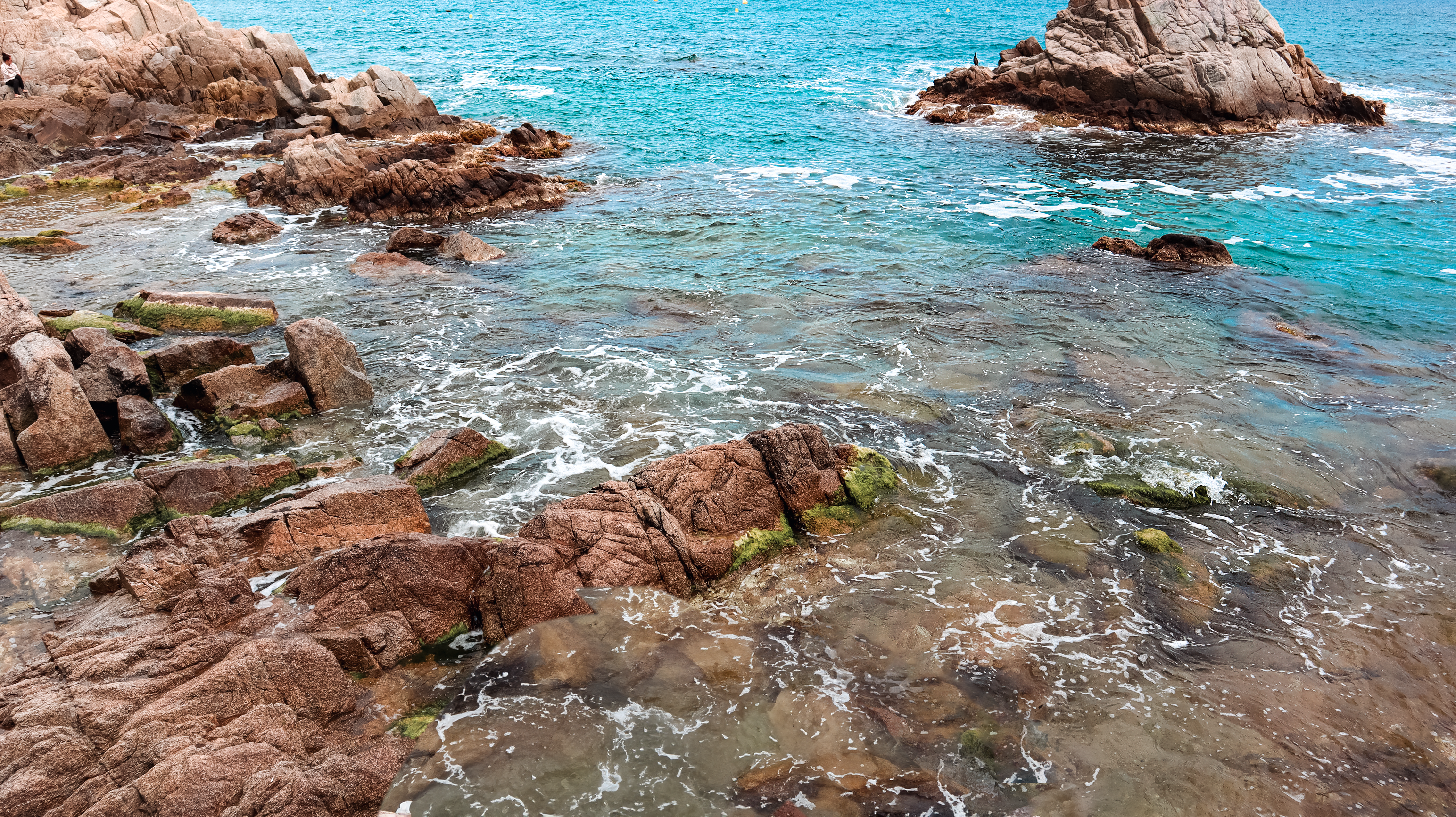 un grande specchio d'acqua circondato da rocce