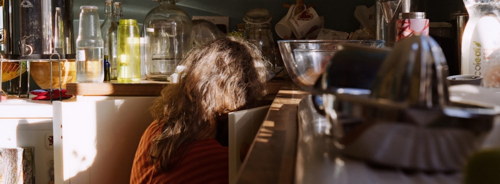 a woman sitting at a counter in a kitchen