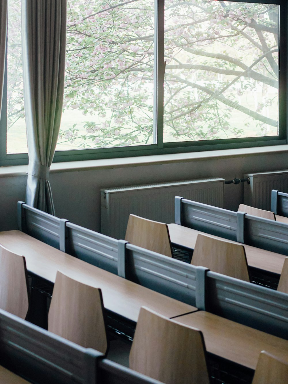 a classroom with rows of desks in front of a window
