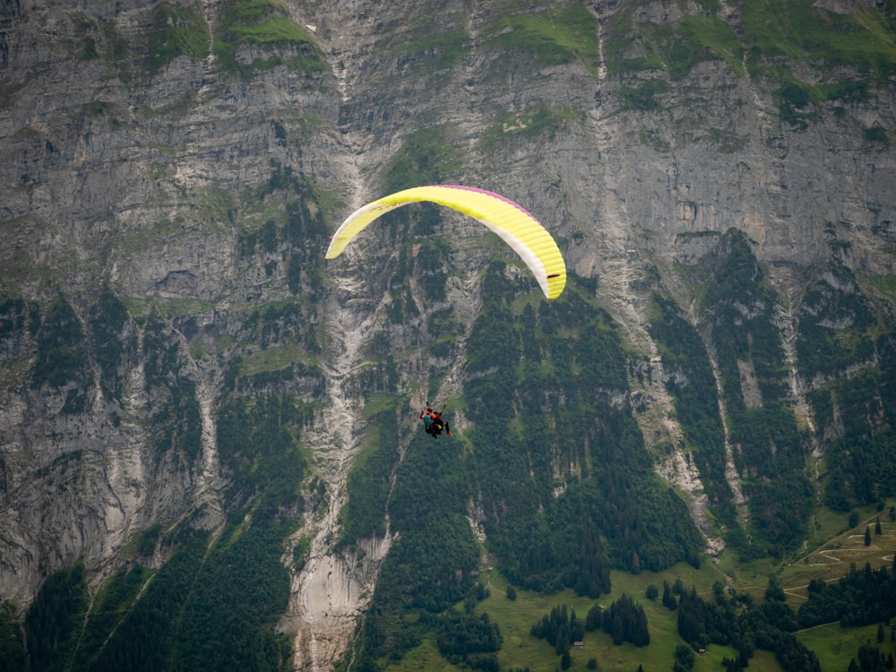 a paraglider is flying over a mountain range