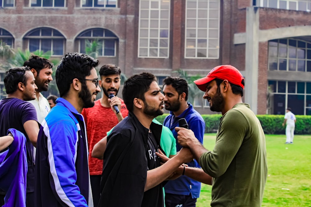 a group of men standing next to each other in front of a building