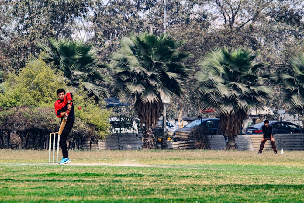 a man playing a game of cricket in a park