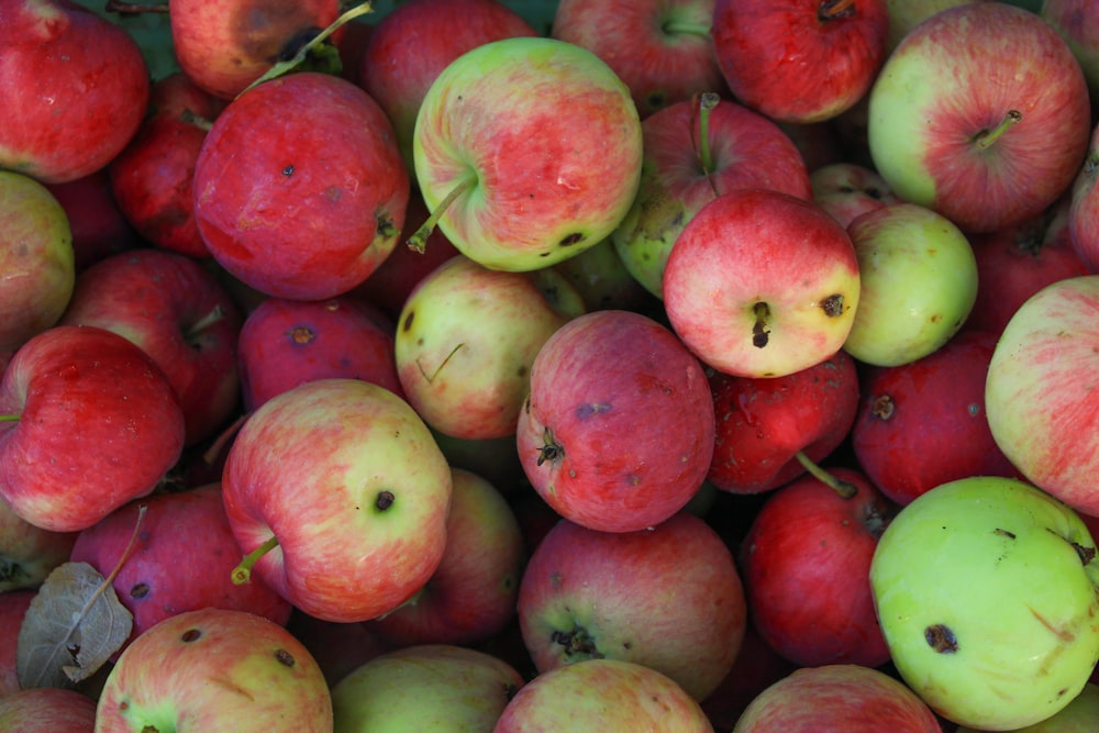 a pile of red and green apples sitting on top of each other