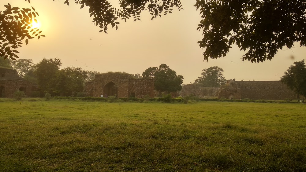 Un campo cubierto de hierba con un edificio al fondo