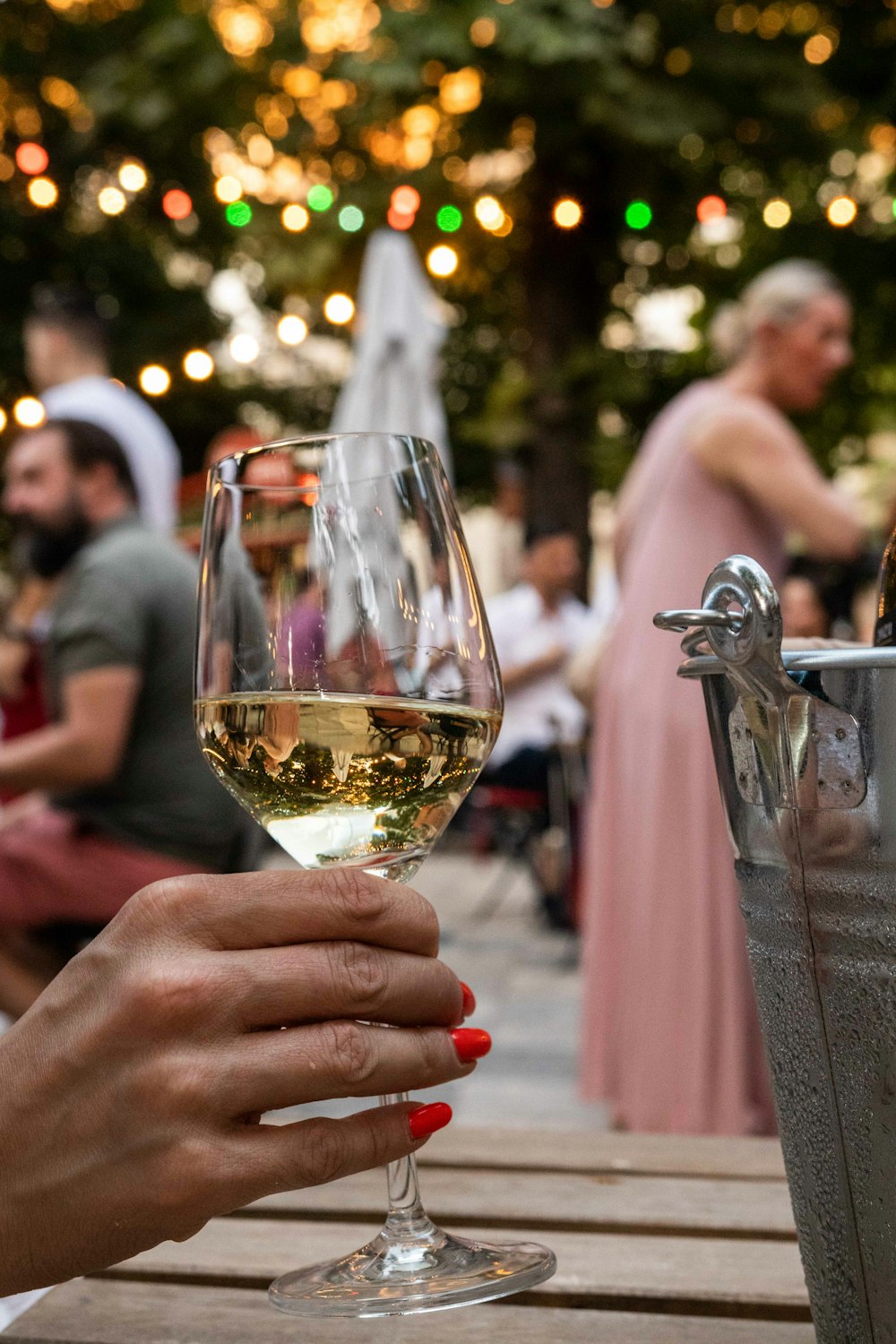 a person holding a glass of white wine