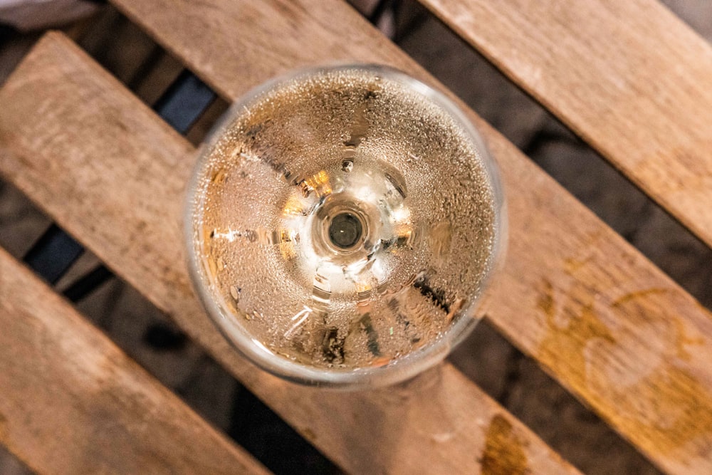 a wine glass sitting on top of a wooden table