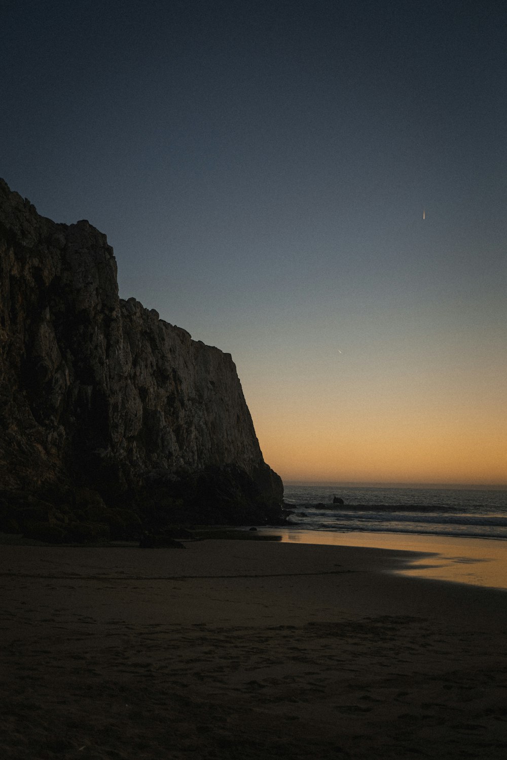 a person standing on a beach next to the ocean