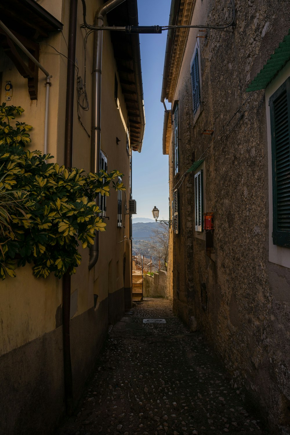 a narrow alley way with a clock tower in the distance