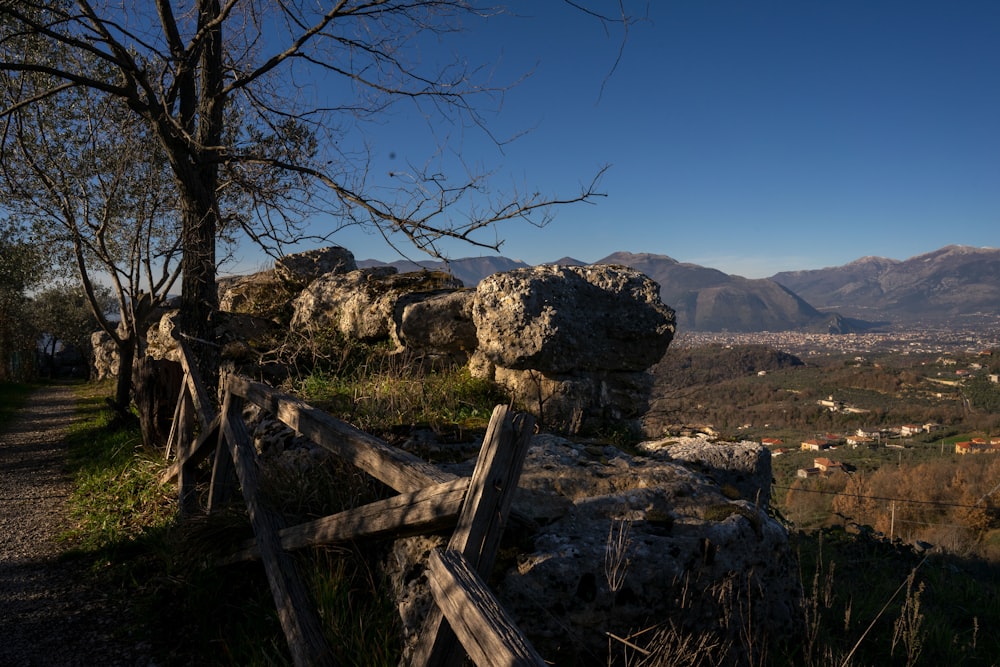 a wooden fence sitting on top of a lush green hillside