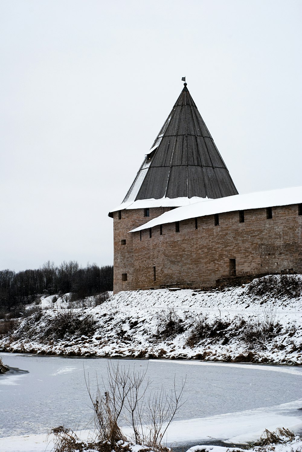 a building with a tower on top of it covered in snow