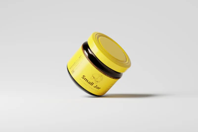 a yellow jar with a black lid on a white surface