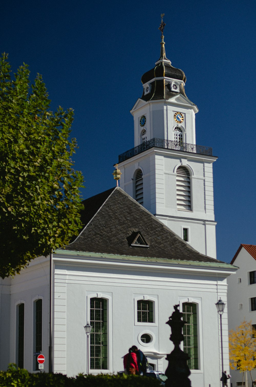 a white church with a clock tower on a sunny day