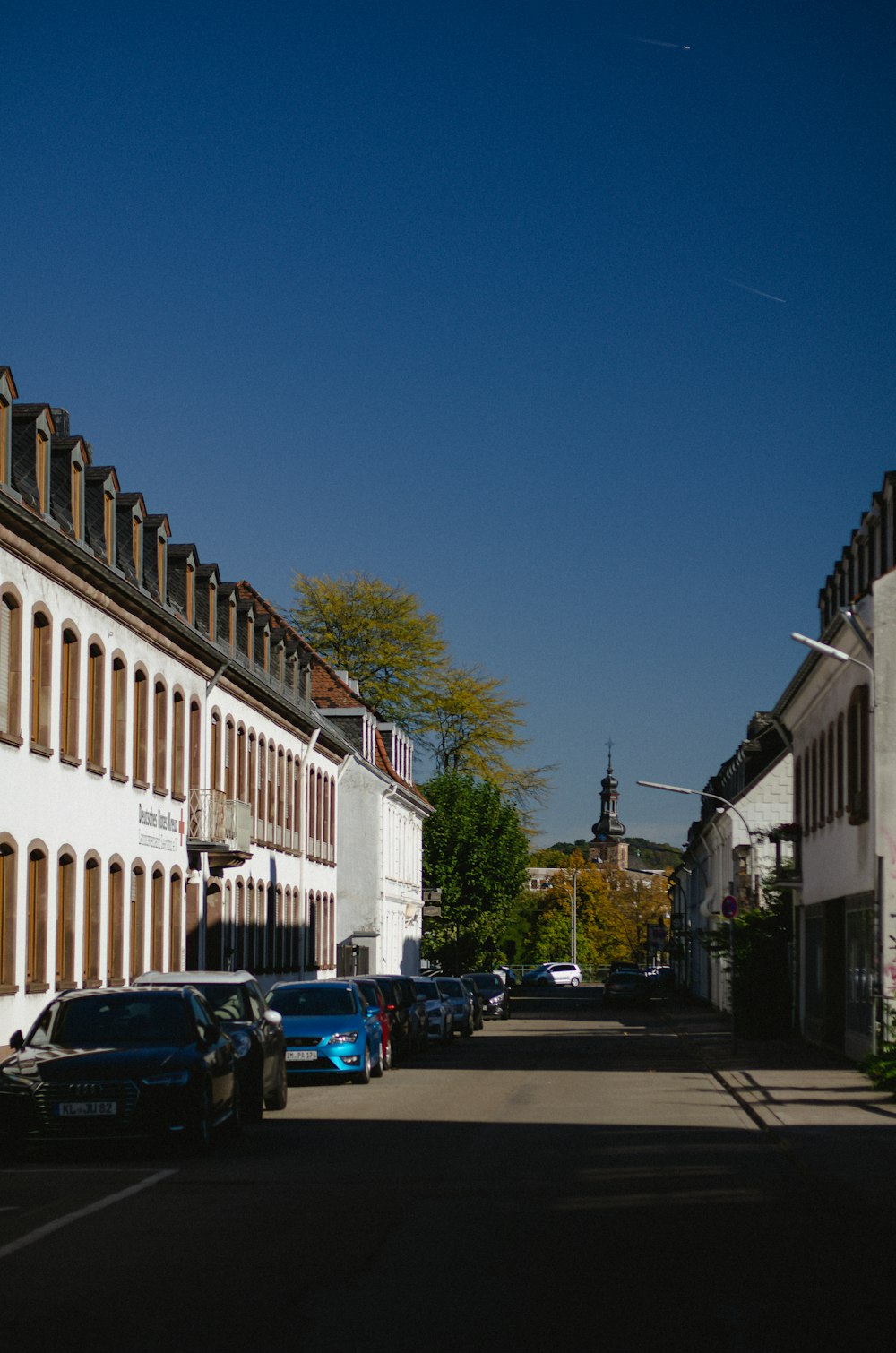 a street lined with parked cars next to tall buildings