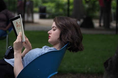a woman sitting in a chair reading a book