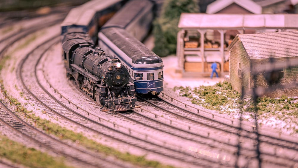a model train on a track with a building in the background