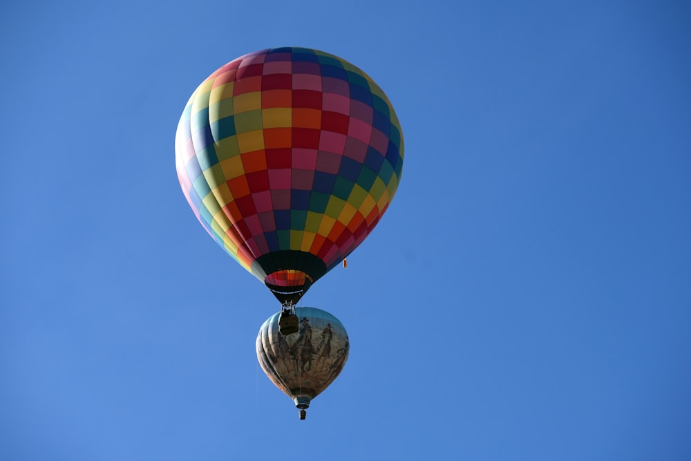 a colorful hot air balloon flying through a blue sky