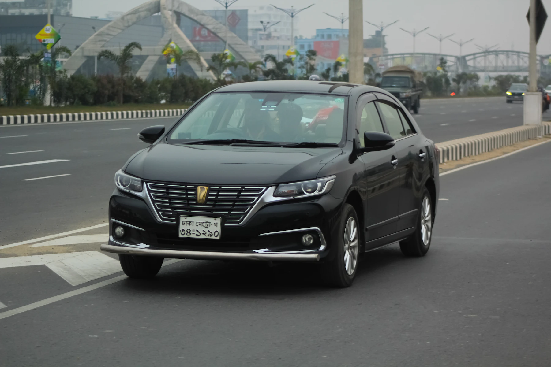 Black Toyota Premio sedan driving on a city road