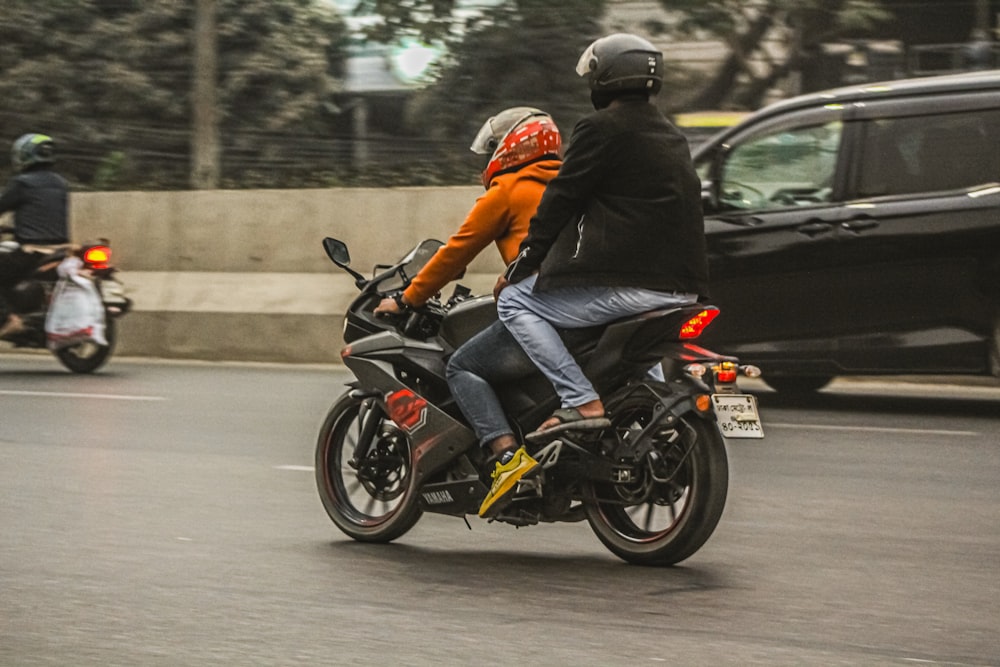 two people riding a motorcycle on a city street