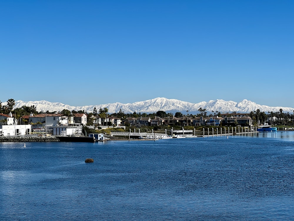 a body of water with houses and mountains in the background