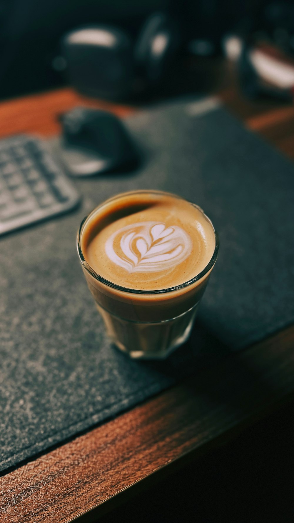 a cup of coffee sitting on top of a wooden table