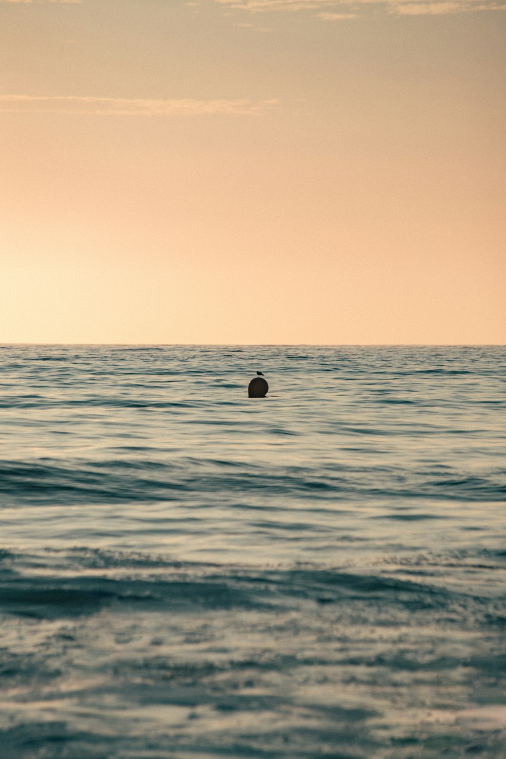 a lone boat floating in the middle of the ocean