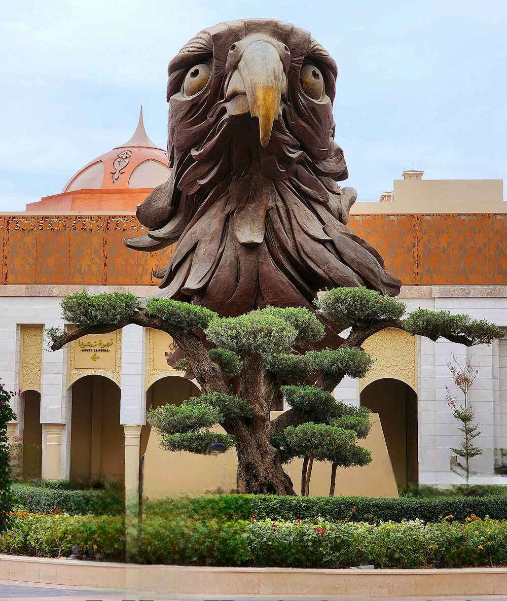 a statue of an eagle with a tree in front of it