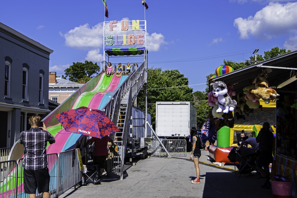 a person standing on a street next to a carnival ride