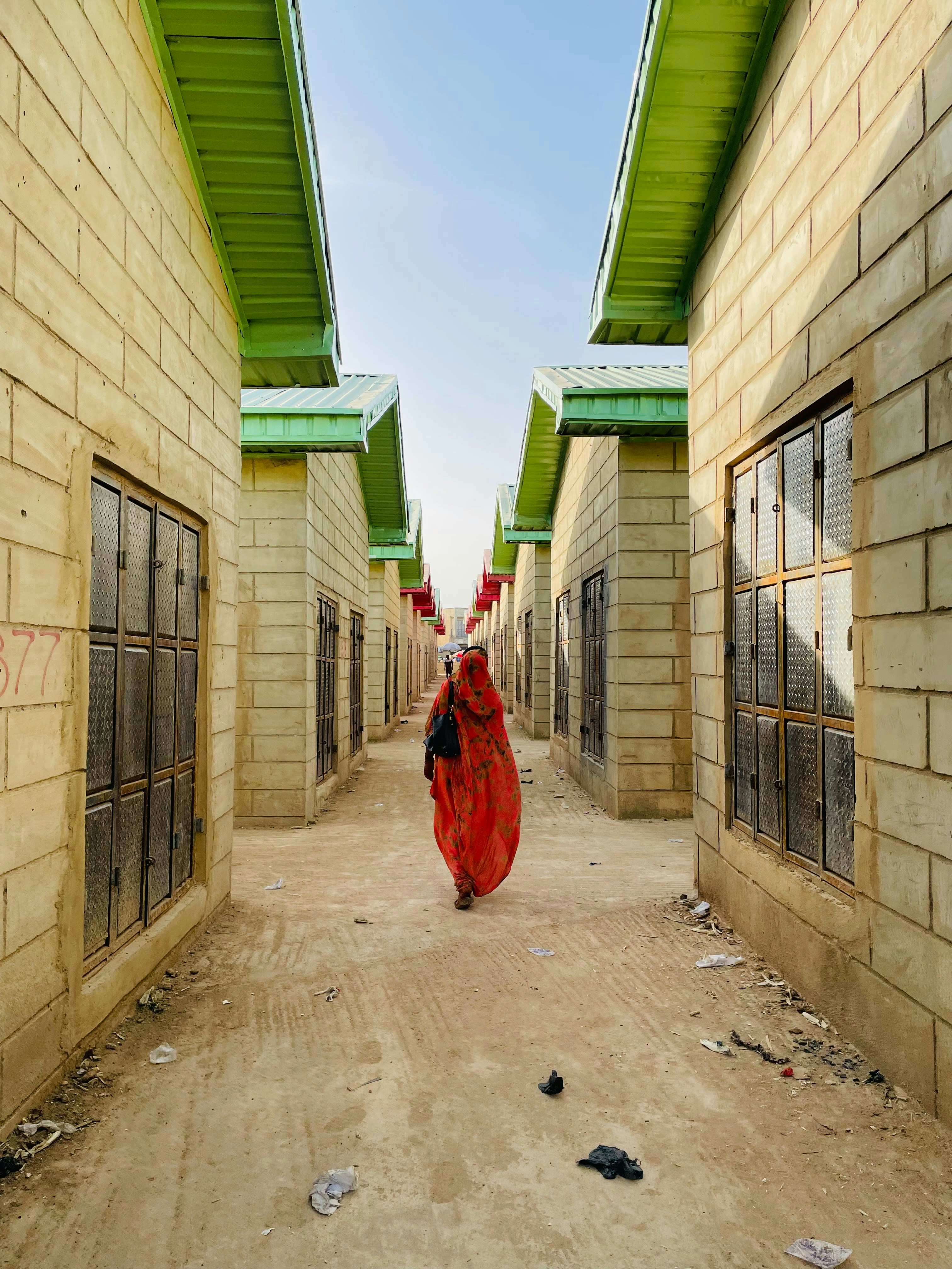 a woman in a red dress walking down a street