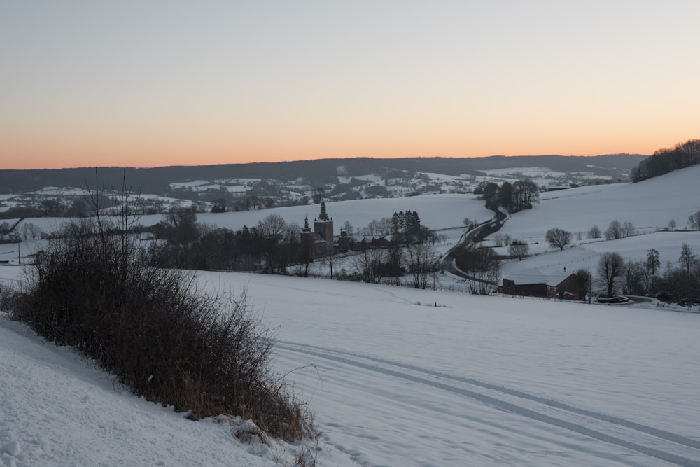 a snow covered field with a hill in the background