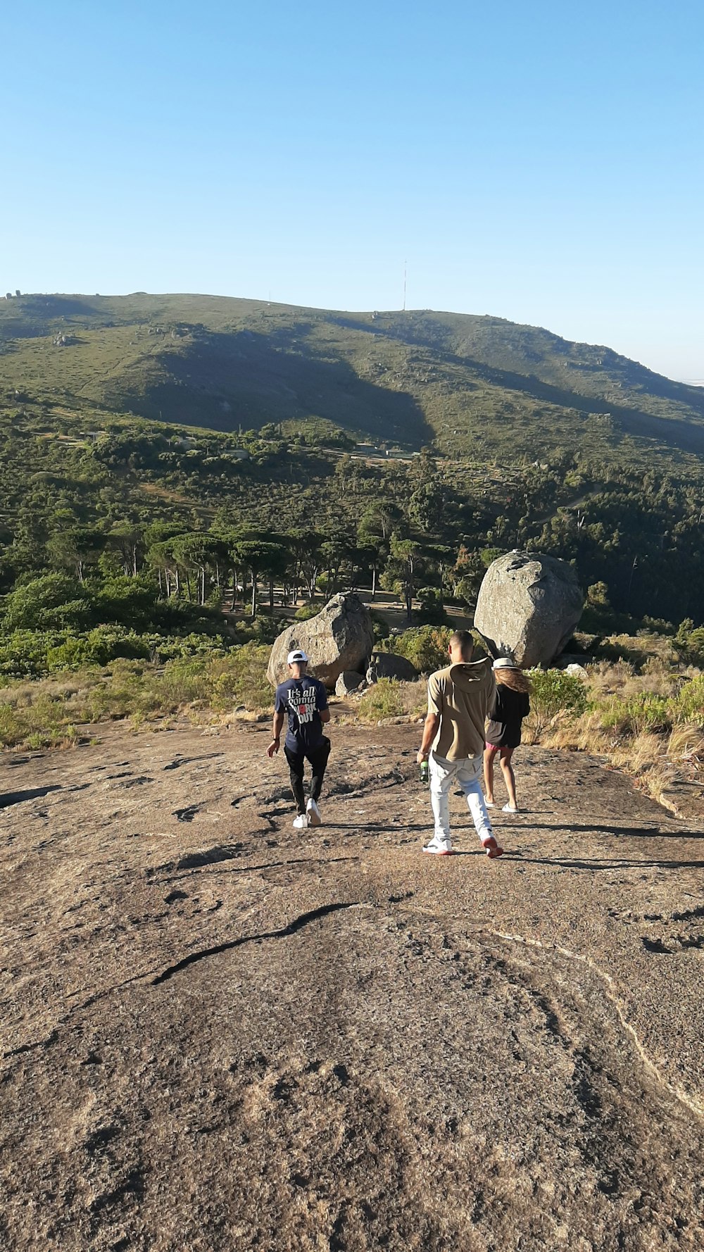 a group of people walking across a dirt field