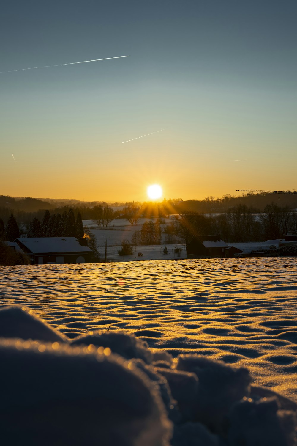 el sol se está poniendo sobre un campo nevado