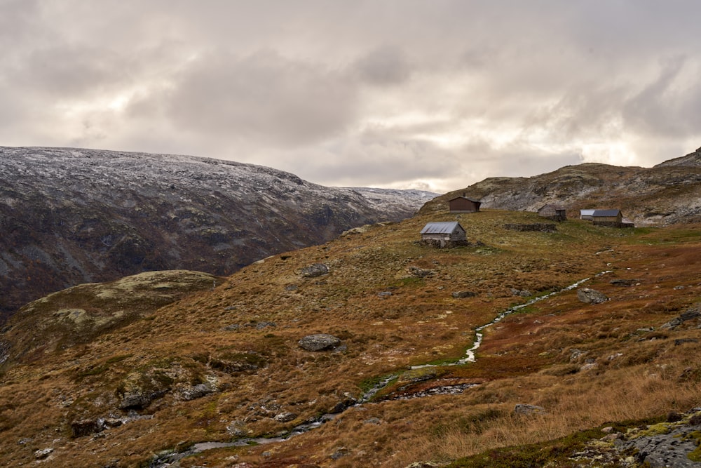 a grassy hill with a small house on top of it