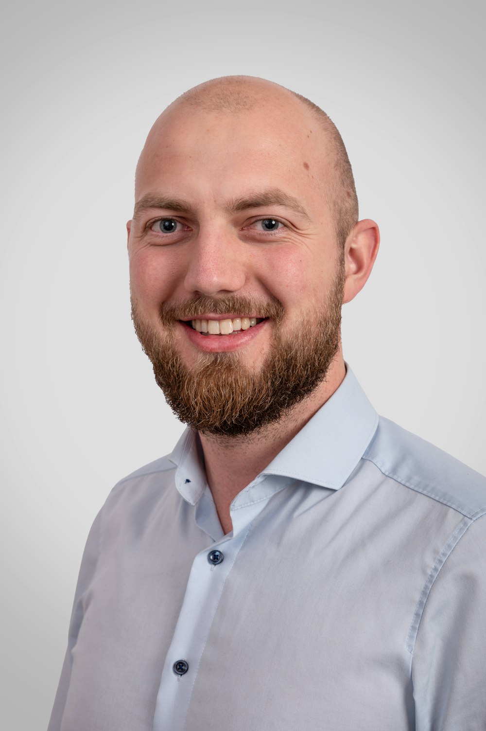 a man with a bald head wearing a blue shirt