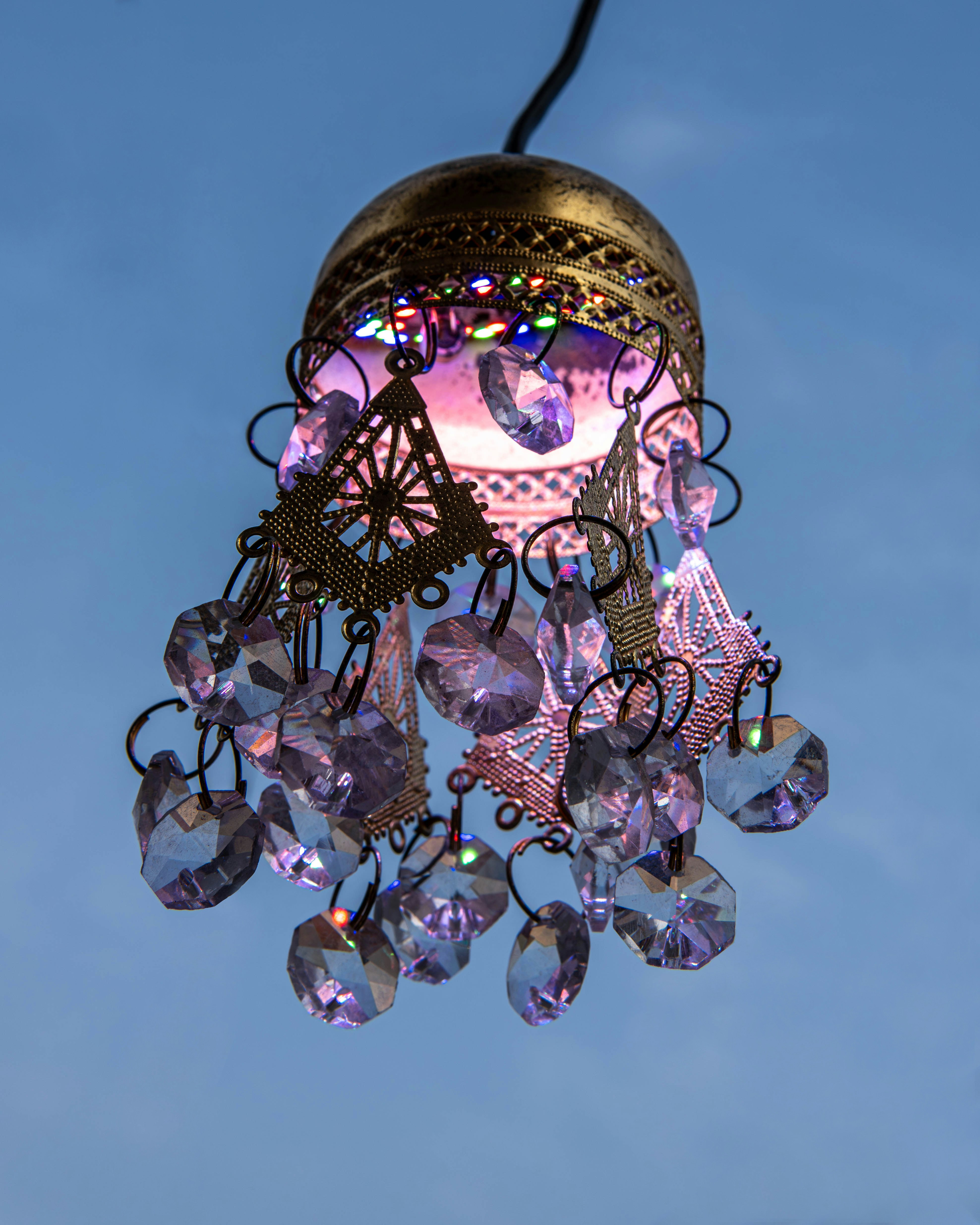 a chandelier hanging in the air with a blue sky in the background