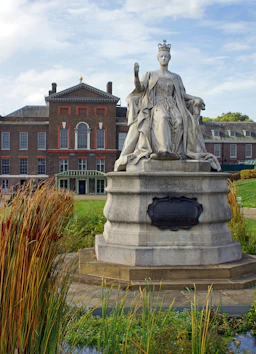a statue of a woman with a crown in front of a building