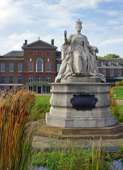 a statue of a woman with a crown in front of a building