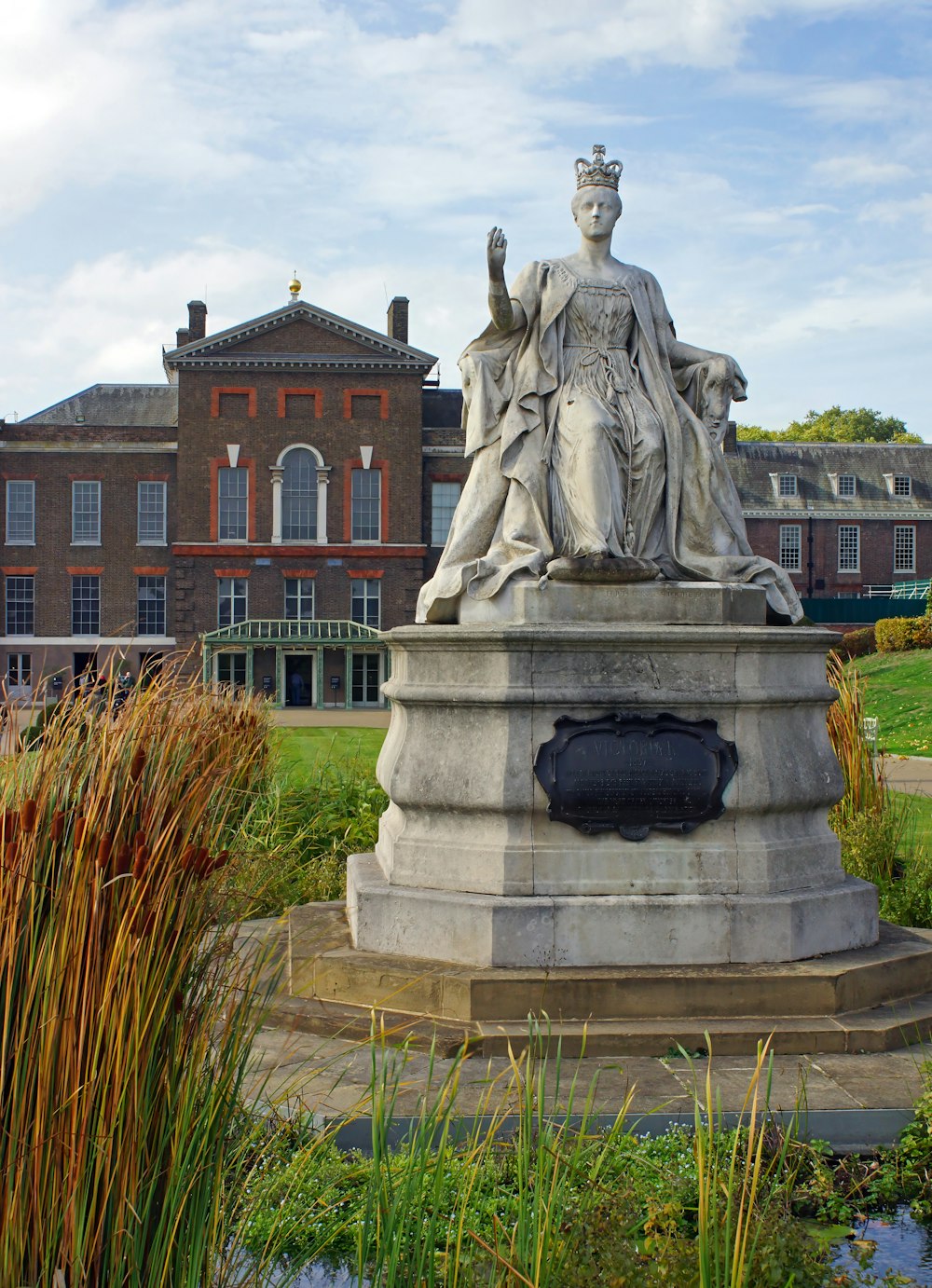 a statue of a woman with a crown in front of a building