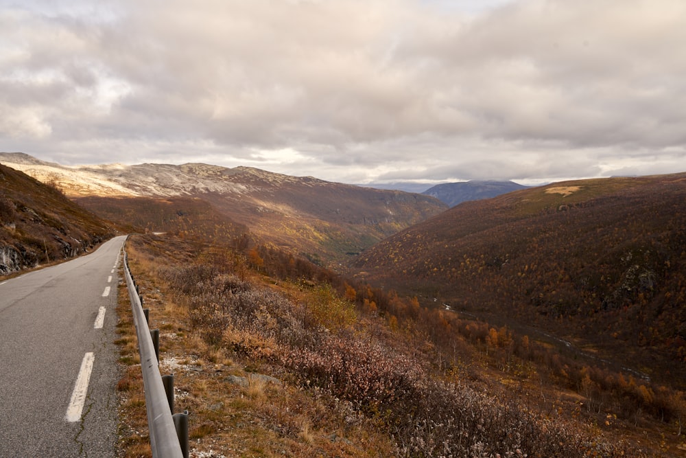 a road going through a valley with mountains in the background