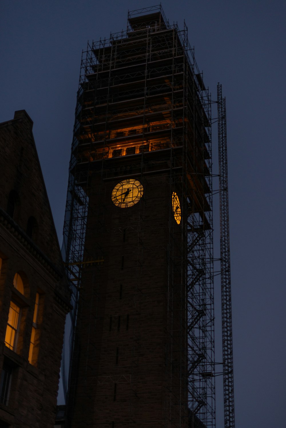 a clock tower with scaffolding around it at night