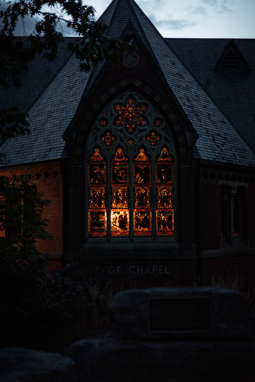 a church with a lit up window at night