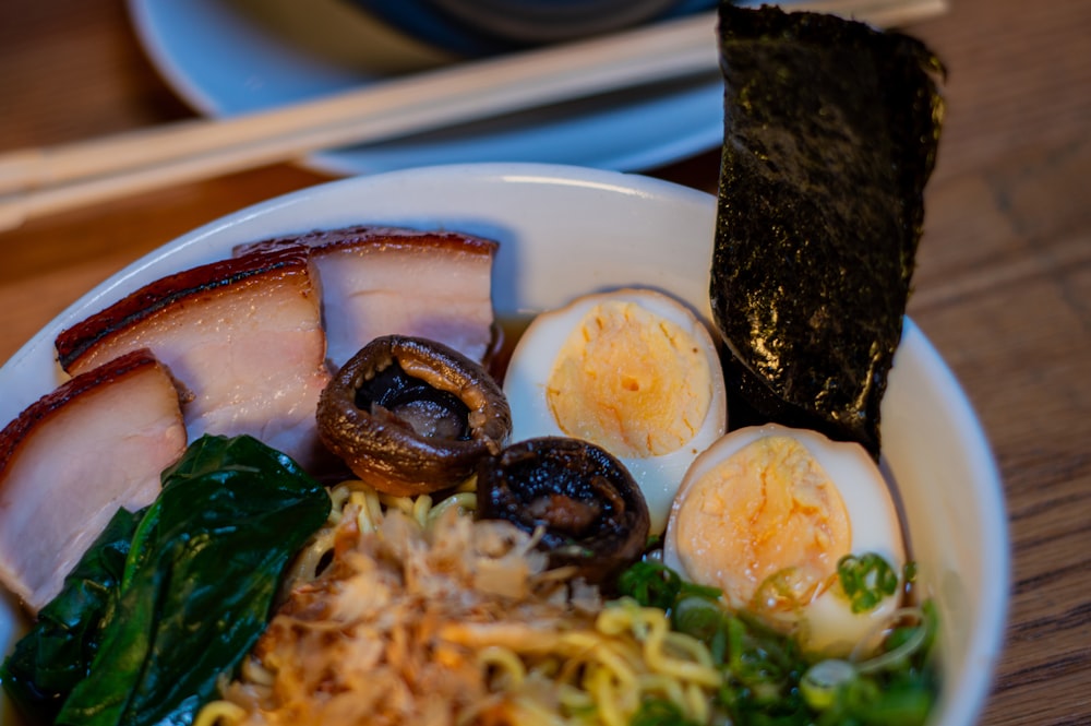 a bowl of food with eggs, meat, and vegetables