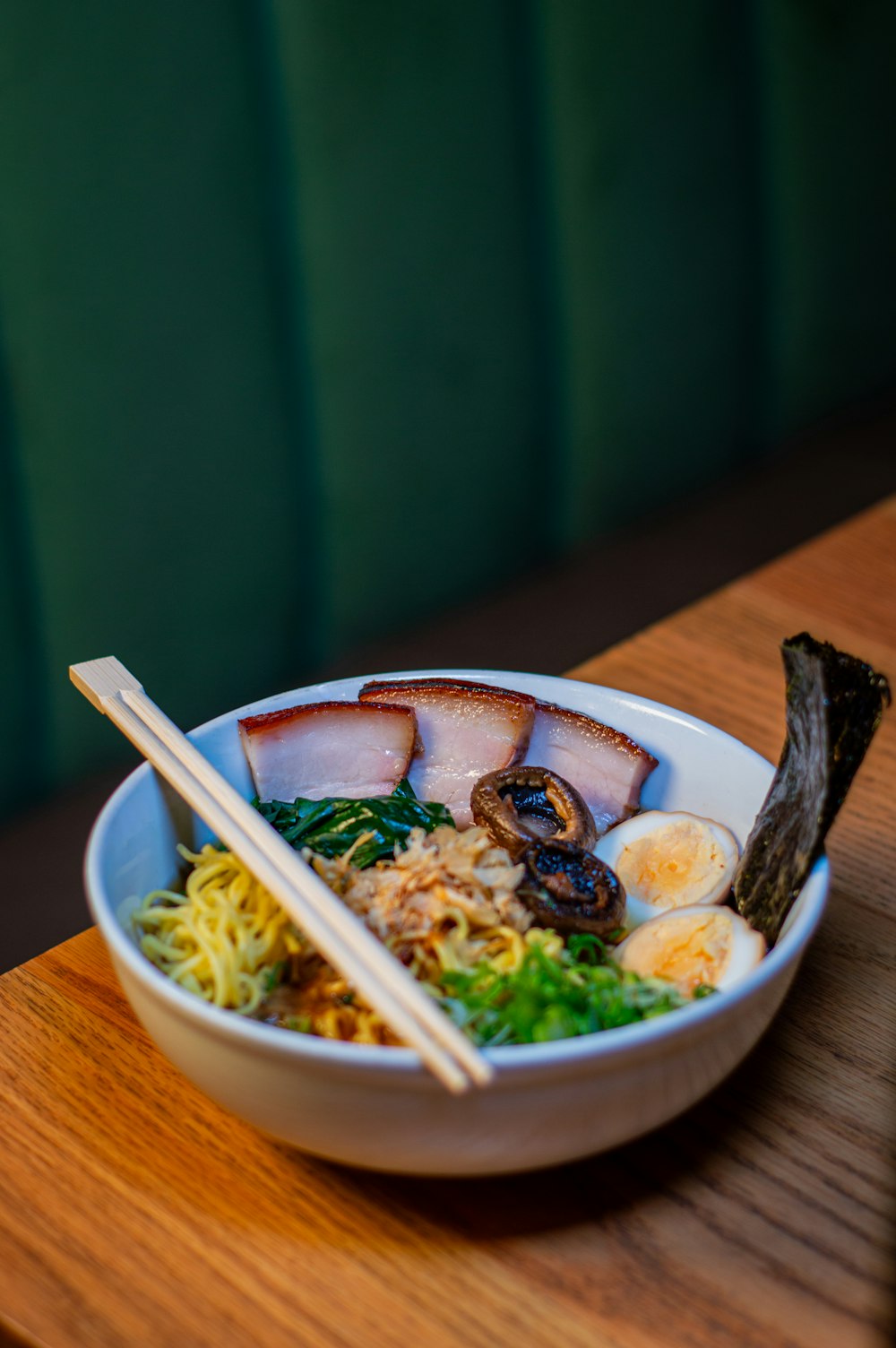 a bowl of food with chopsticks on a table