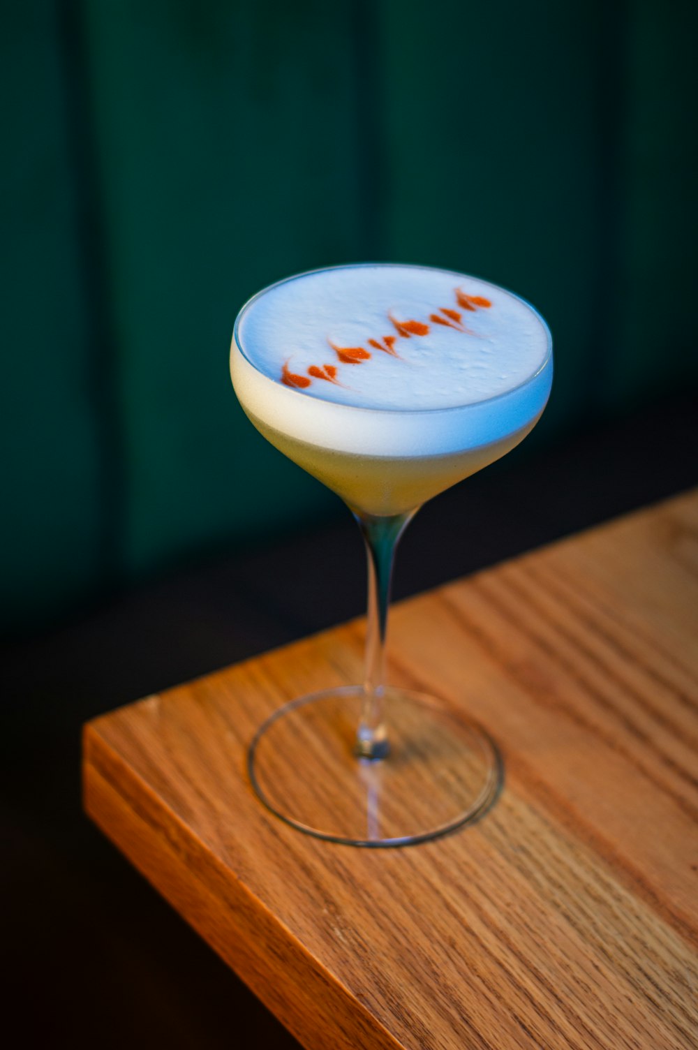 a white and orange drink sitting on top of a wooden table