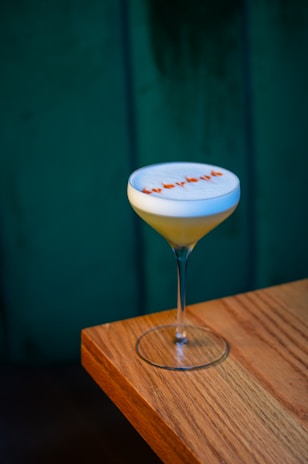 a white and orange drink sitting on top of a wooden table