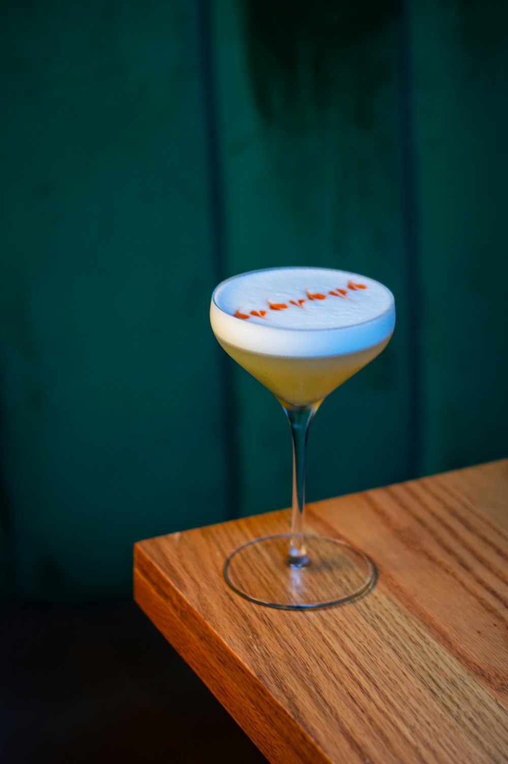a white and orange drink sitting on top of a wooden table