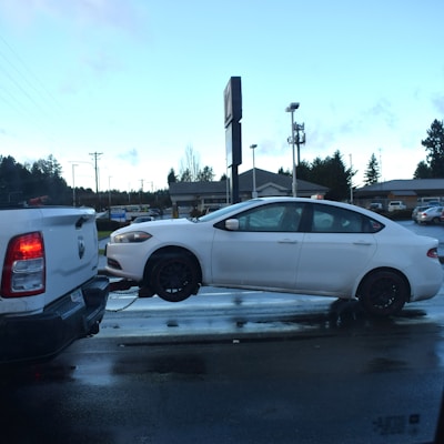 a white car being towed by a tow truck