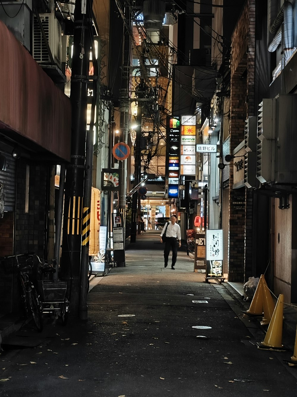 a person walking down an alley way at night